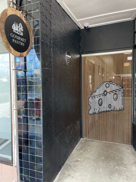 Bronze aluminium chain screen dividing a restaurant entrance from the dining area