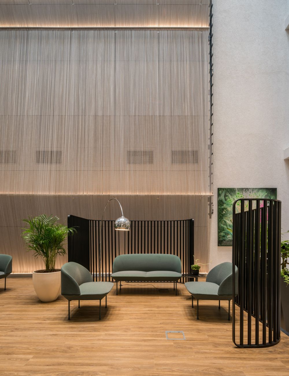 Aluminium chain partition dividing a modern lounge seating area with plants and pendant lighting