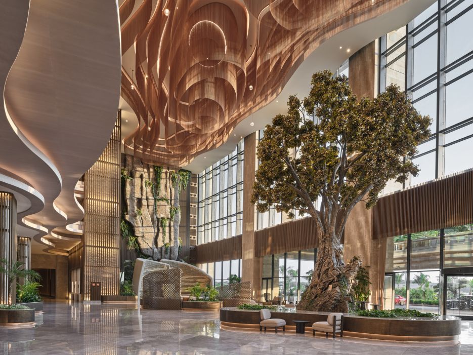 Kriskadecor chain feature ceiling installation in a luxury hotel lobby atrium with a feature tree